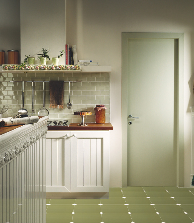 Kuchyně nebo spíž s obklady Ceramiche Grazia Retrò 2 v odstínu šalvějové zelené, s kostkovanou podlahou a dřevěnými doplňky.